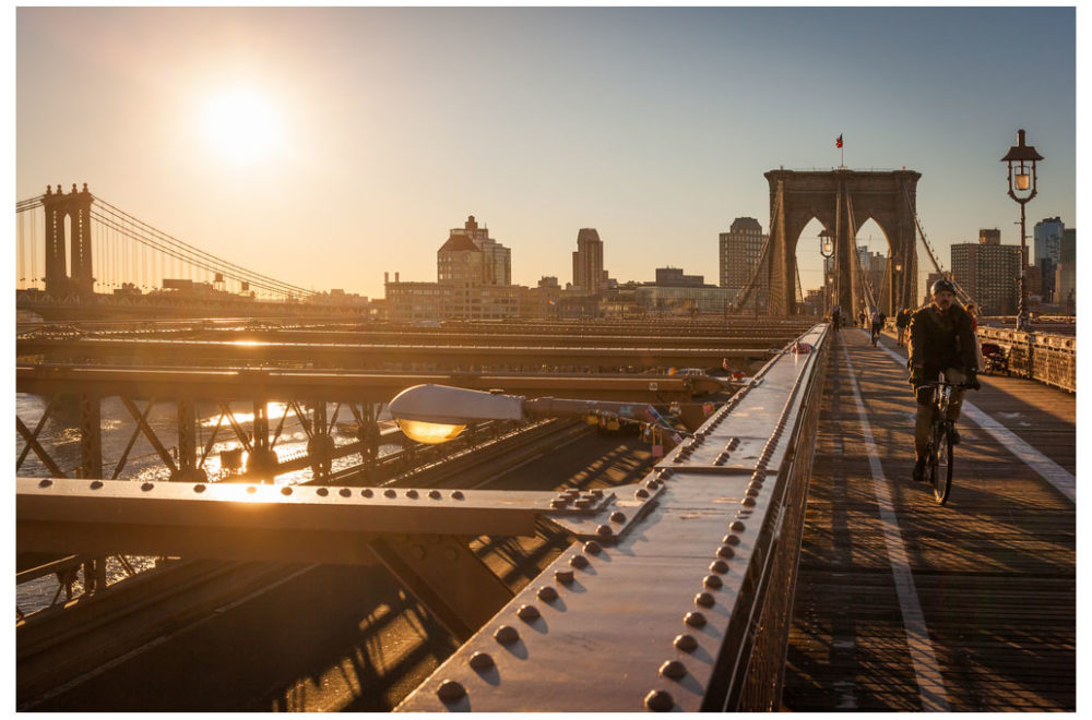 Cyclist commutes across the Brooklyn Bridge in New York City