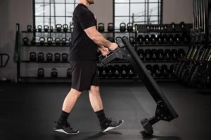 Man packing up portable weight bench