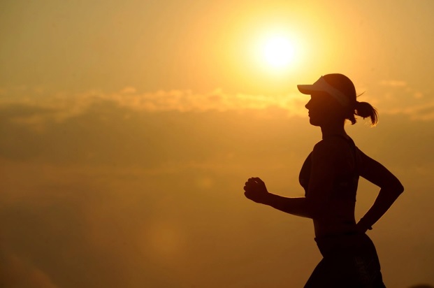 Women running with sun behind her