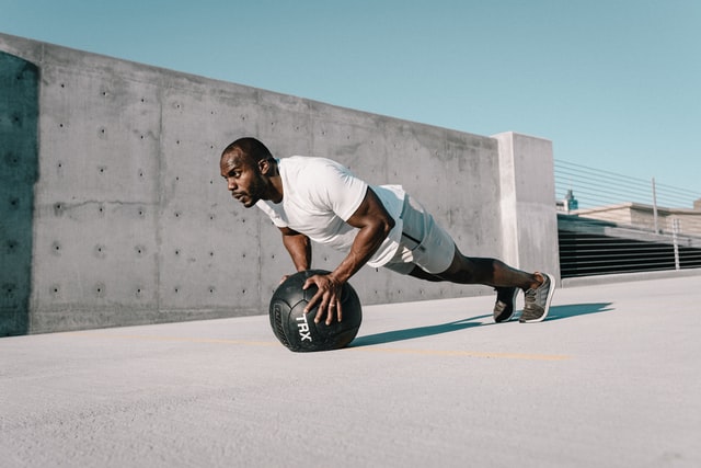 Man doing incline push ups on exercise ball
