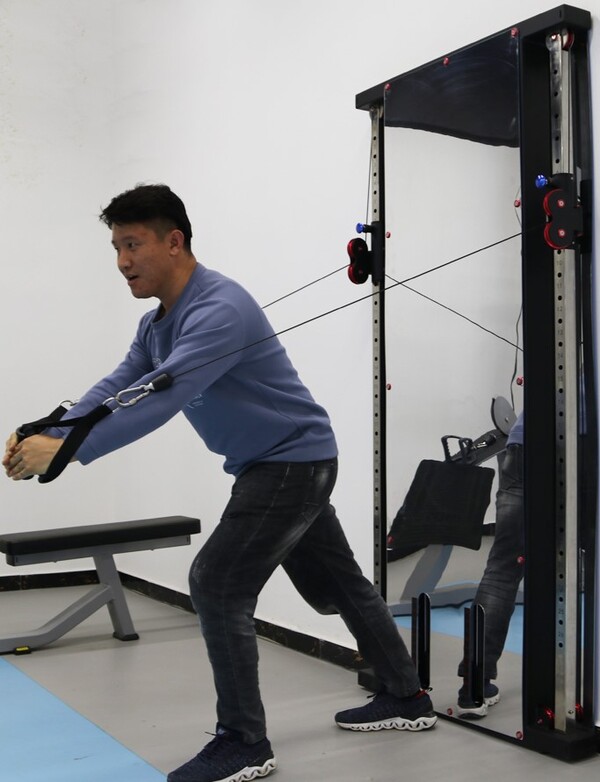 Man showing cable reach of functional trainer