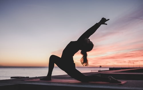 Lady on beach doing yoga