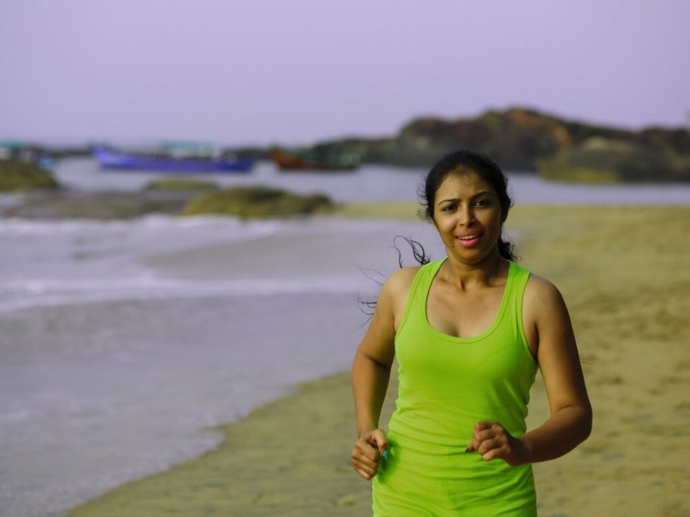 woman jogging on the beach performing calisthenics training