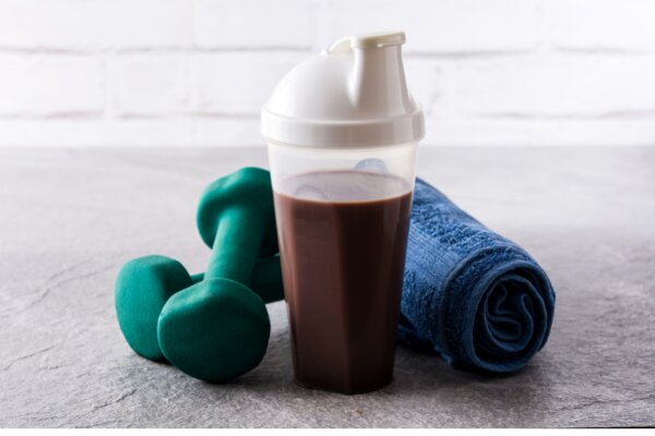 protein shake with a blue towel and dumbells