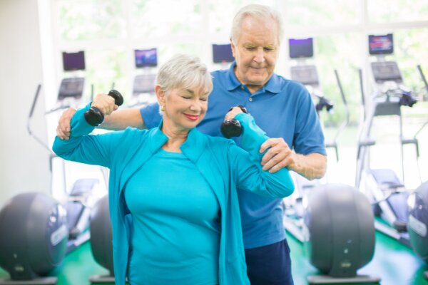 a couple performing free weight exercises