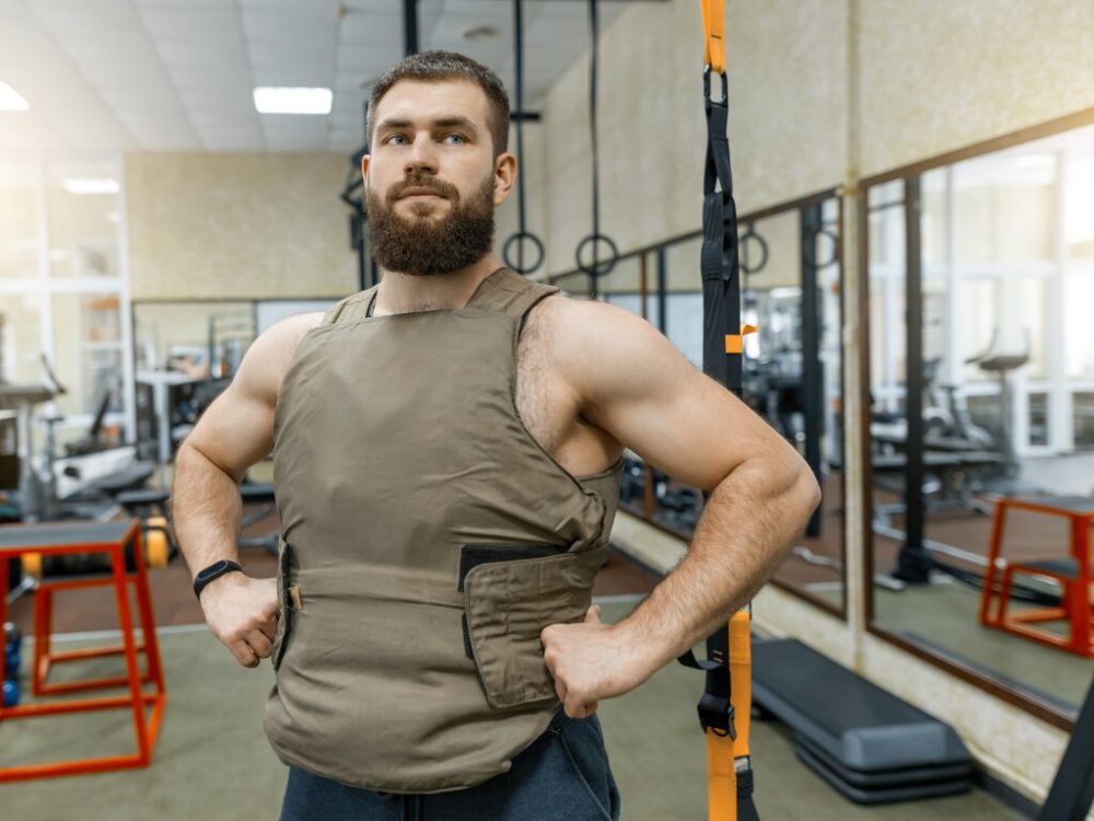 man standing in weighted vest ready for training
