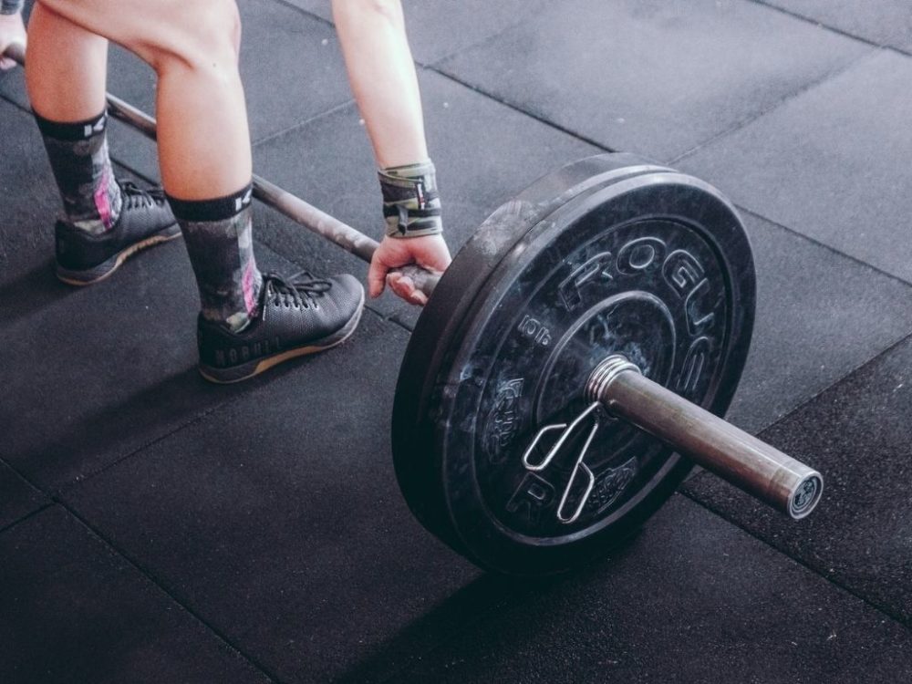 man picking up barbell