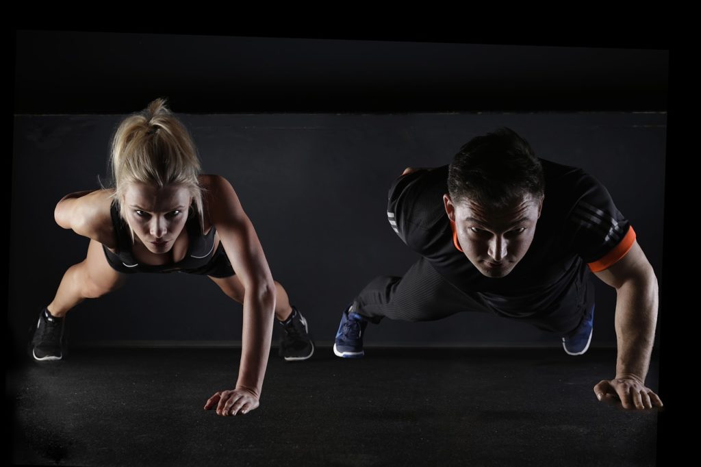 man and woman doing one hand pushups