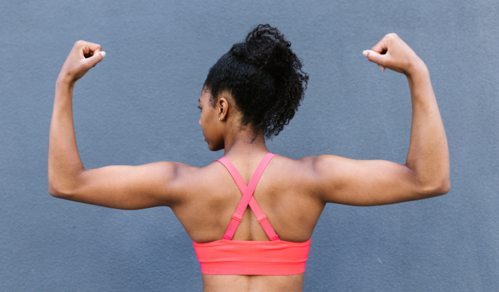 woman flexing muscles in beginner calisthenics program