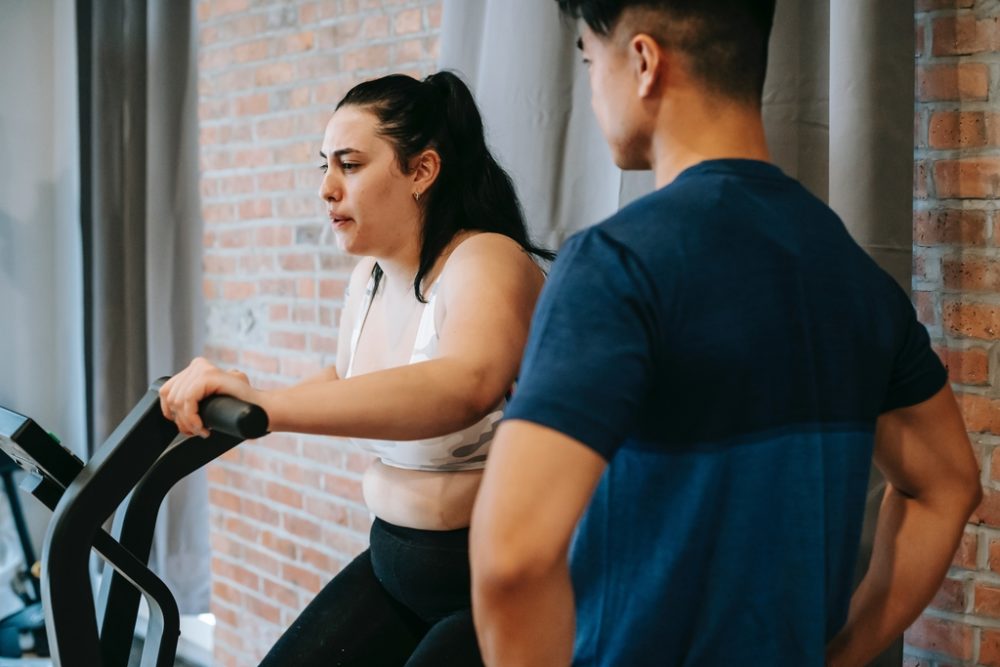 Instructor helping woman on rogue echo bike