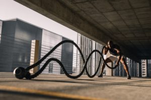 Man using battle ropes in parking lot