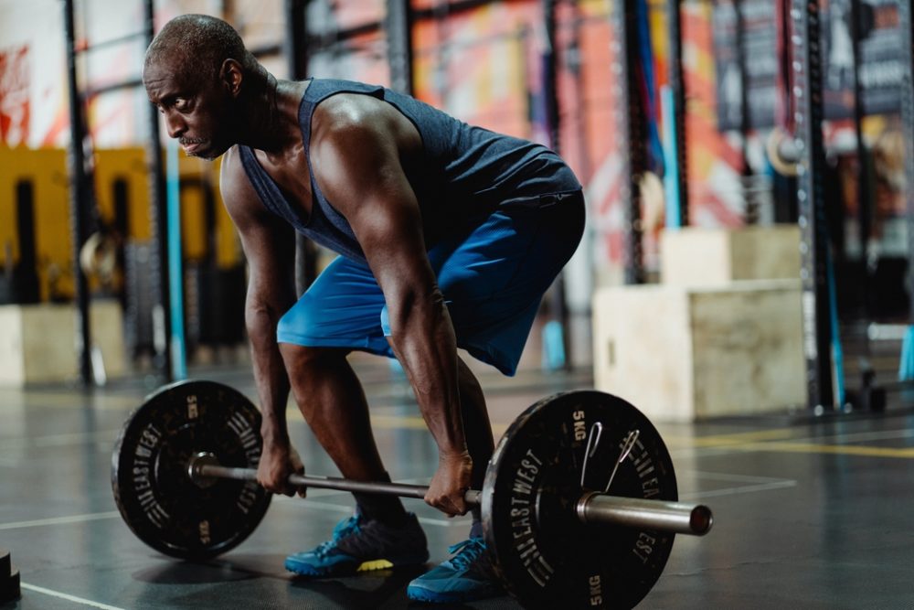 Man about to perform deadlift in weightlifting shoes