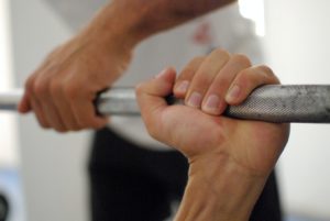 Man's hand on knurling on barbell