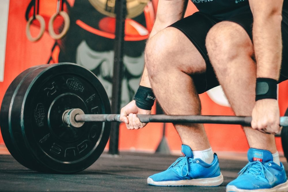 Person gripping a barbell with heavy weights