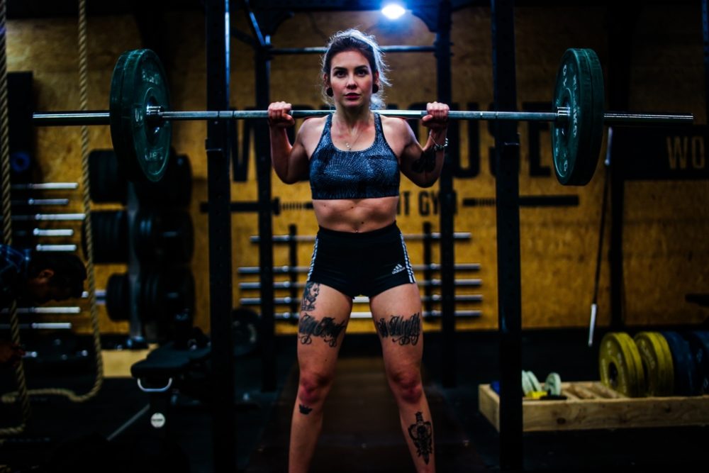 Woman lifting a barbell on back