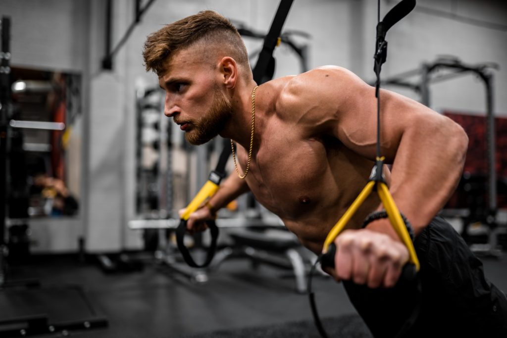 Man using suspension trainer and best calisthenics equipment