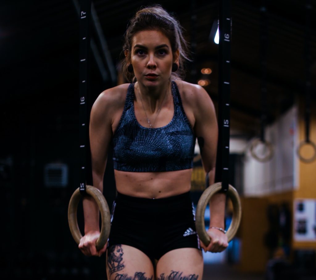 Woman exercising on gymnastic rings calisthenics equipment