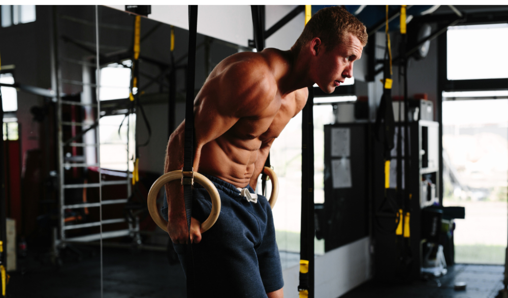 Man using gym rings in gym