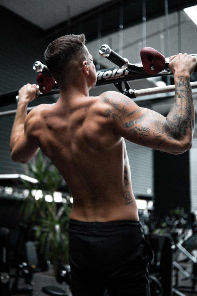 Man at the top of a pull up movement