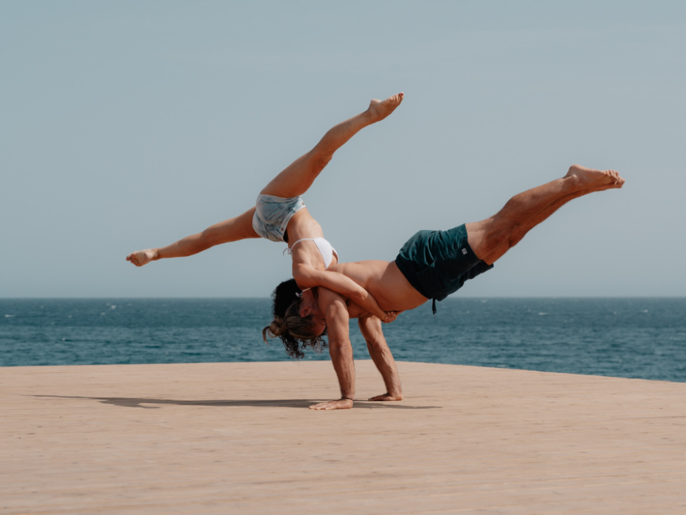 Couple doing a planche push-up on the beach