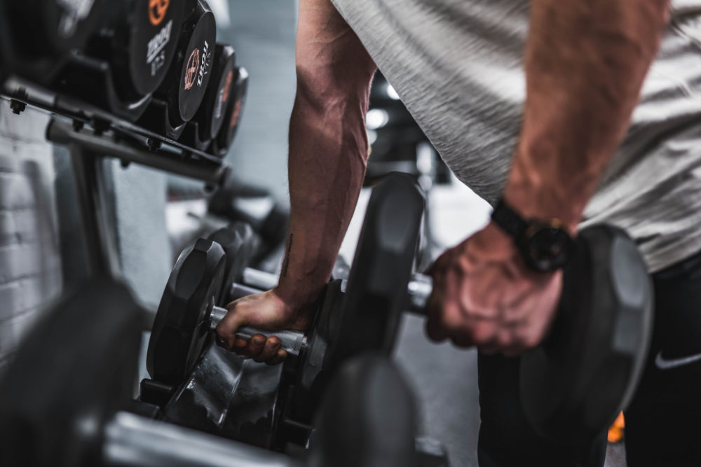 Man grabbing a dumbbell from a stack