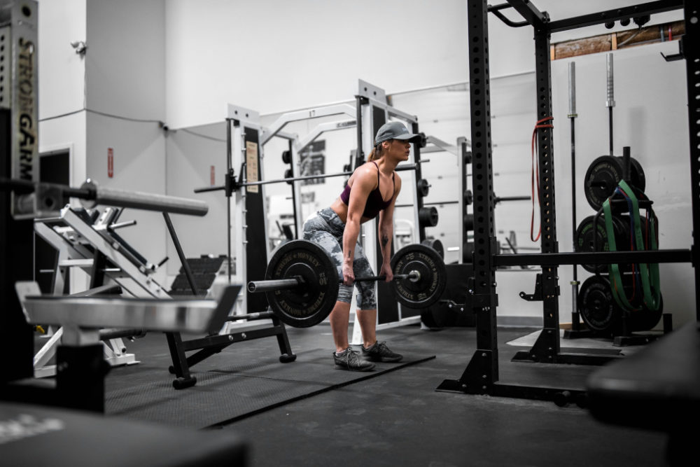 Woman doing pull day workout with barbell