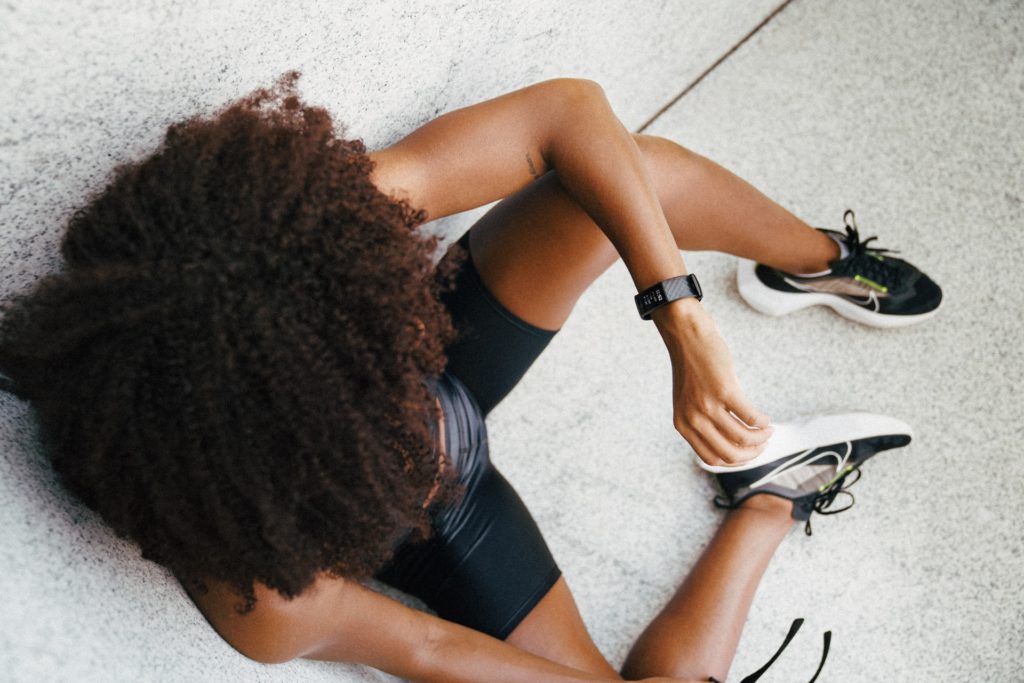 Woman wearing a fitness tracker on the ground - fitness tracker comparison image