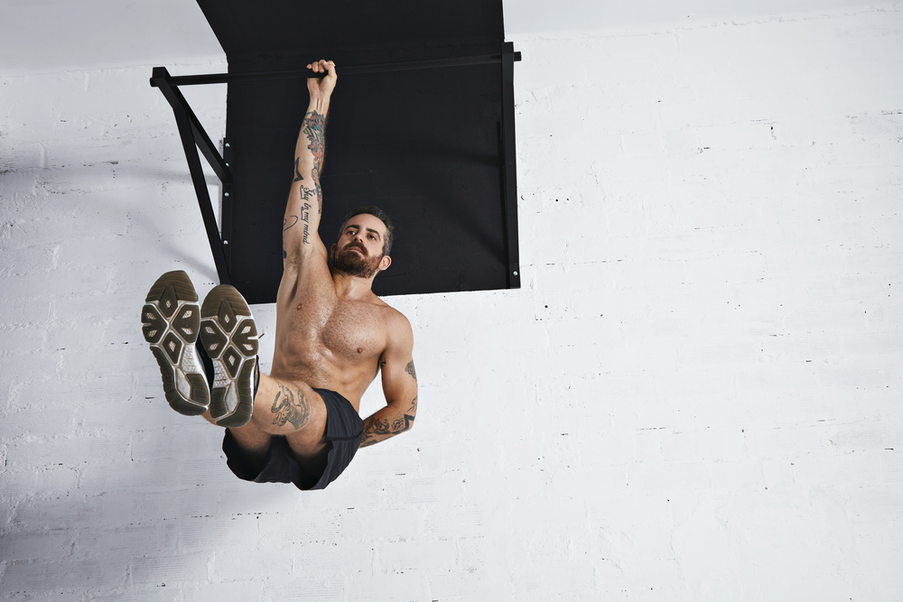 Man doing one arm pull up on pull up bar