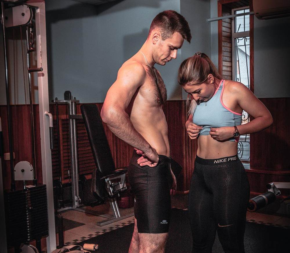 woman checking out her abs by man usa home gym